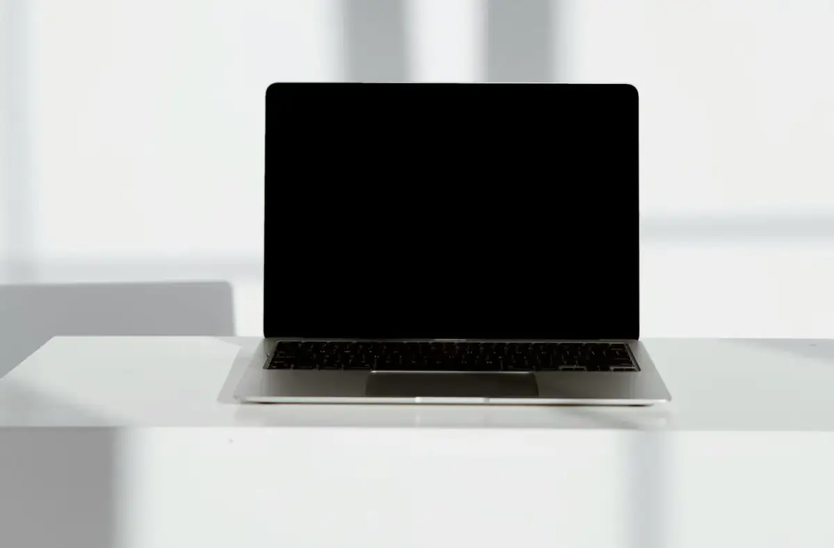 Laptop with a blank black screen on a desk
